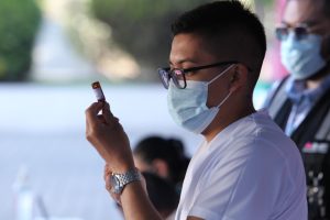 Personal de salud con jeringa en mano preparando la vacuna.