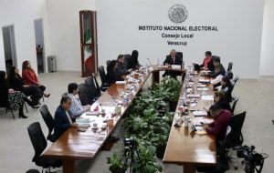 varias personas sentadas alrededor de una mesa en forma de U