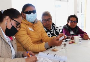 una mujer con debilidad visual sosteniendo una credencial para votar