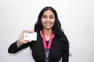 Mujer sonriendo y mostrando su credencial para votar