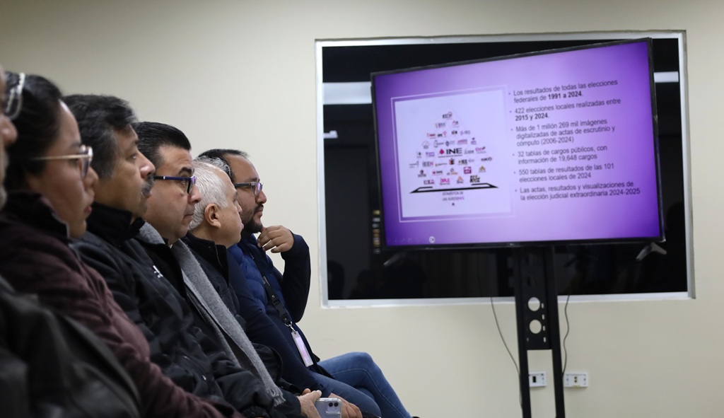 cinco personas viendo una pantalla con un imagen color morado