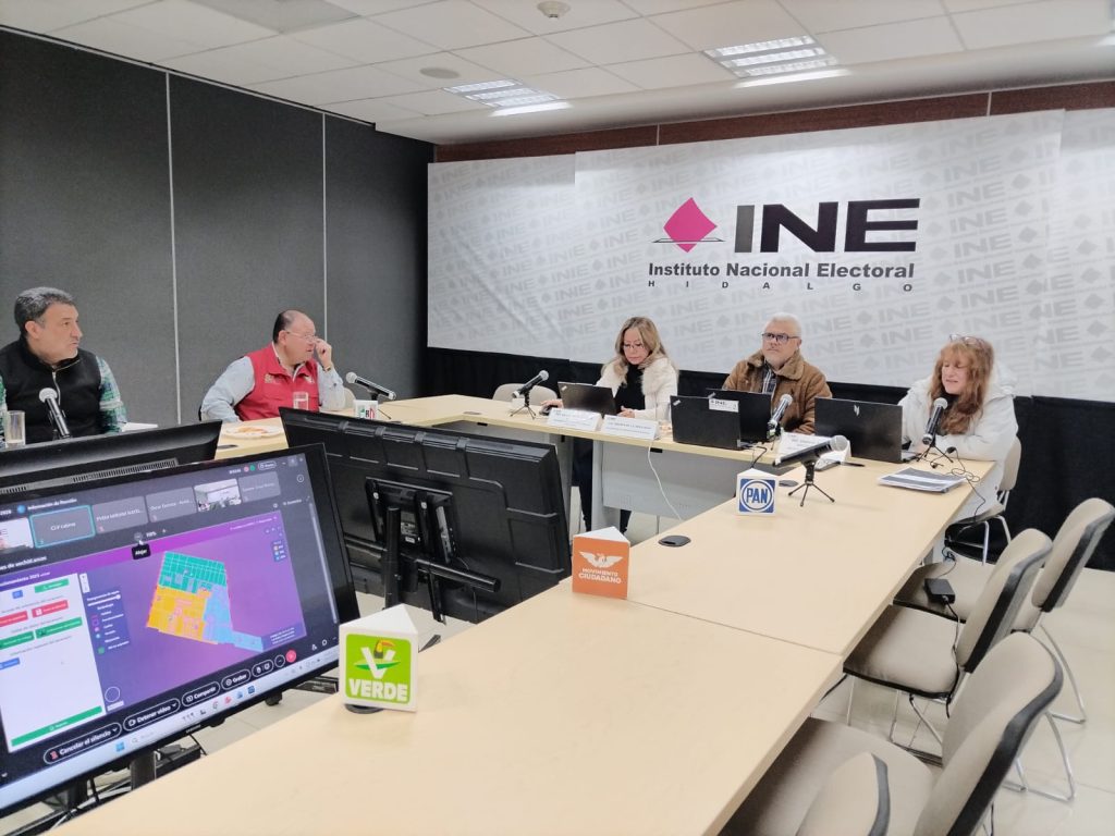 personas sentadas en un salón alrededor de una mesa rectangular