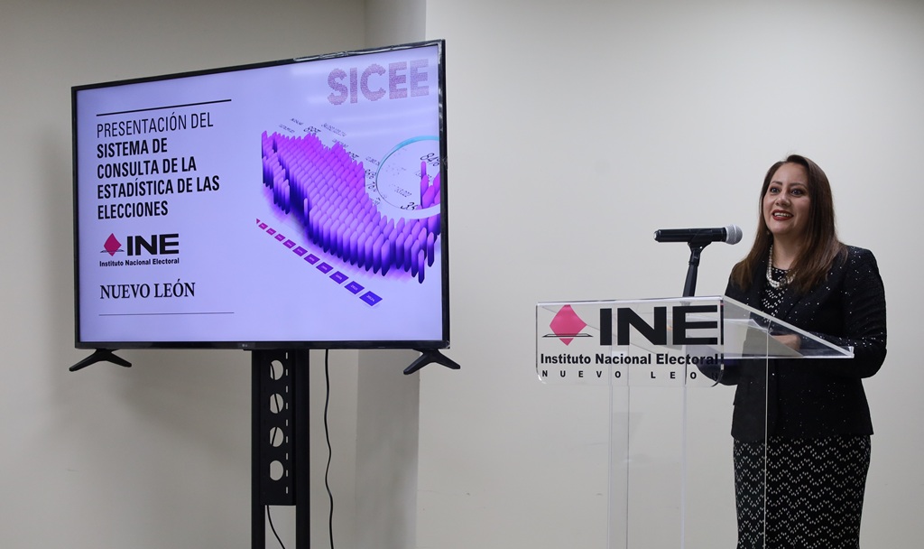 una mujer de pie vestida de negro hablando frente a un micrófono