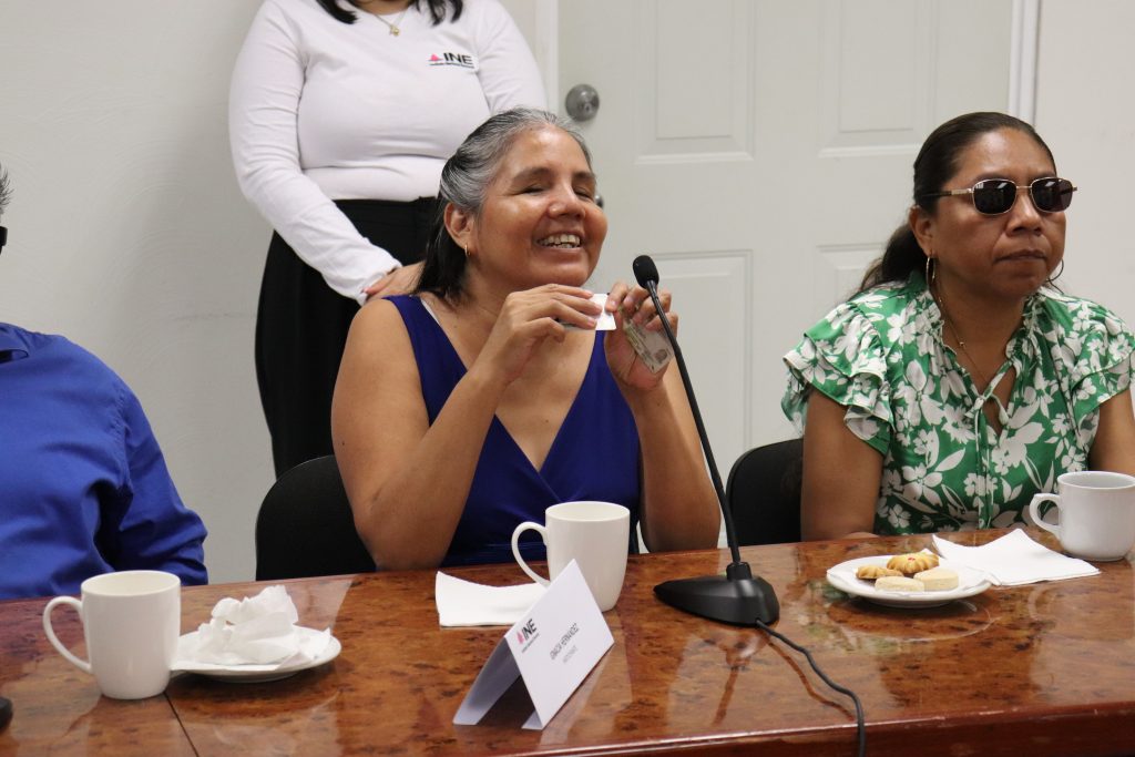 mujer con discapacidad visual sonriendo y tocando un plástico
