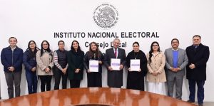varias mujeres y hombres de pie sosteniendo un documento