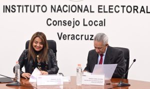 una mujer de mediana edad y un hombre mayor firmando papeles