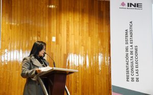 una mujer de pie frente a un atril con micrófono