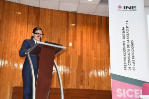 Una mujer cabello recogido de pie frente a un micrófono