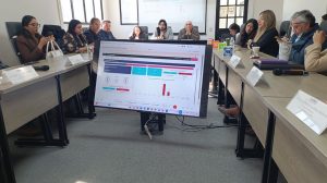 varias personas sentadas alrededor de una pantalla de televisión