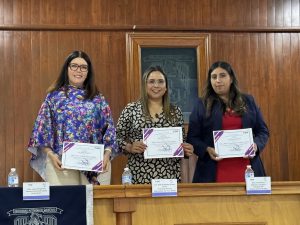 tres mujeres de pie sosteniendo, cada una, un reconocimiento