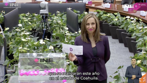 Edecán sosteniendo letrero con la Letra "D"