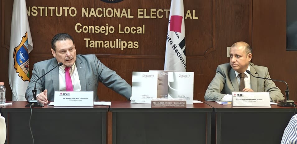 Dos hombres sentados frente a dos micrófonos en medio tres libros