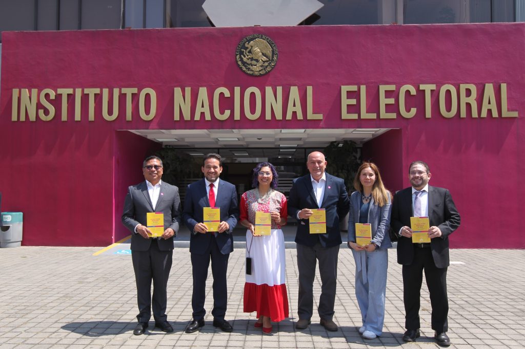 Personas participantes posando para la foto en la explanada del instituto.