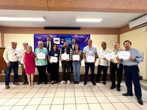 varias personas de pie sosteniendo un diploma