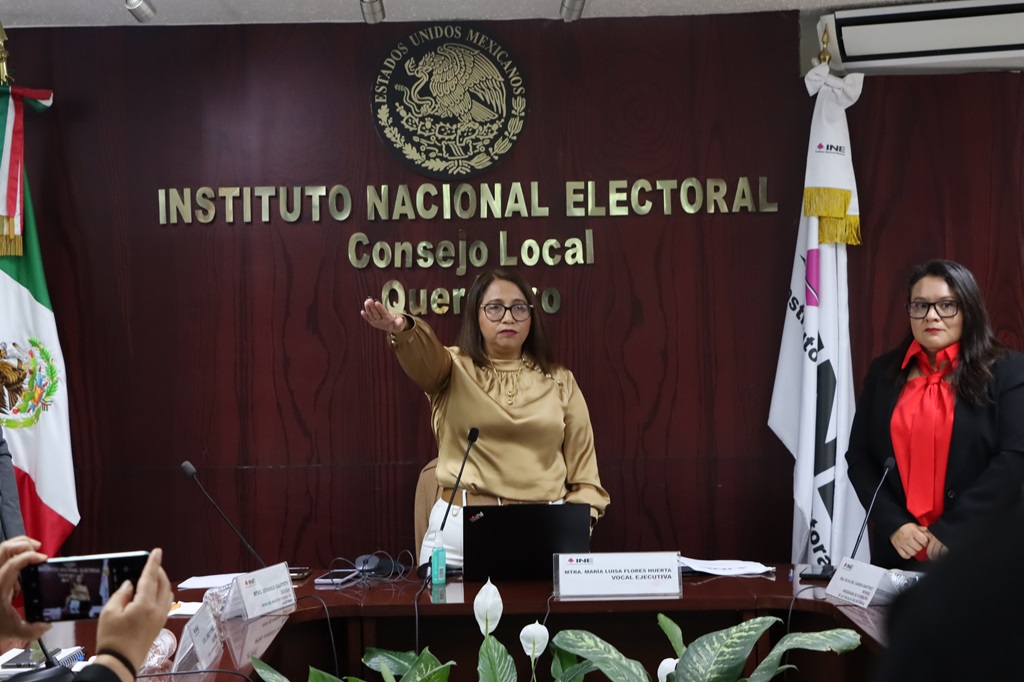 Dos mujeres de pie detrás de una mesa larga