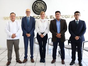 Cinco personas de pie vestidos formalmente