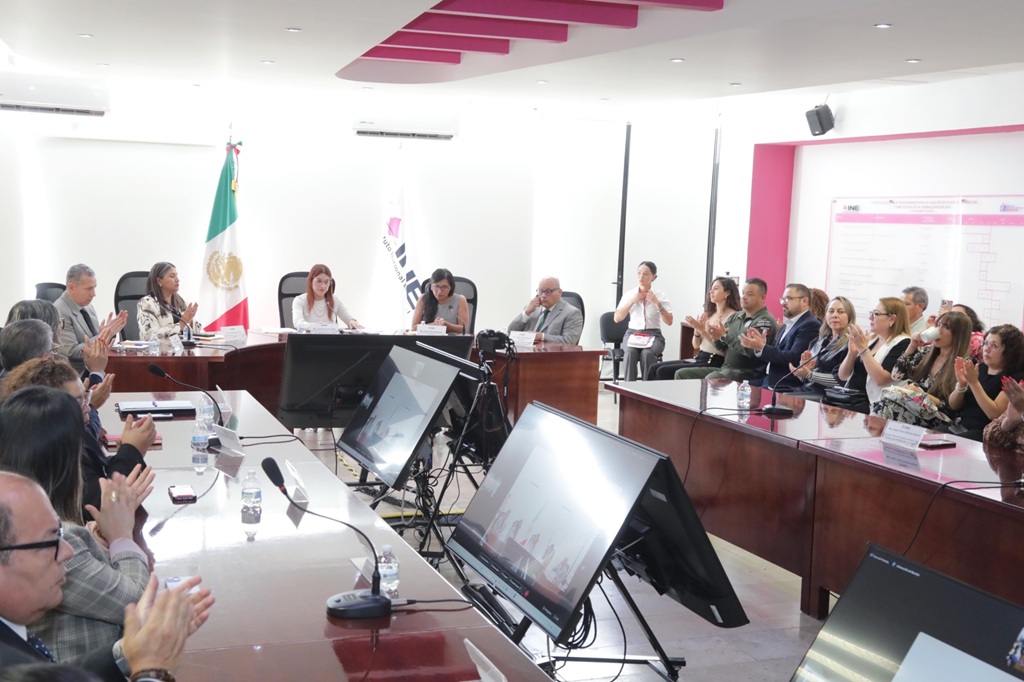 personas reunidas en un salón aplaudiendo