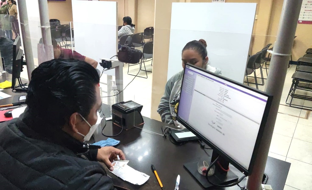 un trabajador del INE atendiendo a una mujer