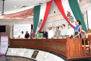 Diez personas de pie reunidas detrás de una mesa