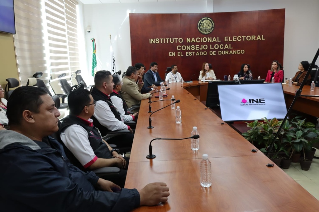 personas sentadas frente a una mesa con micrófonos