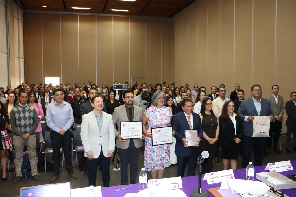 Más de treinta personas reunidas de pie, tres de ellas sostienen un certificado de clausura