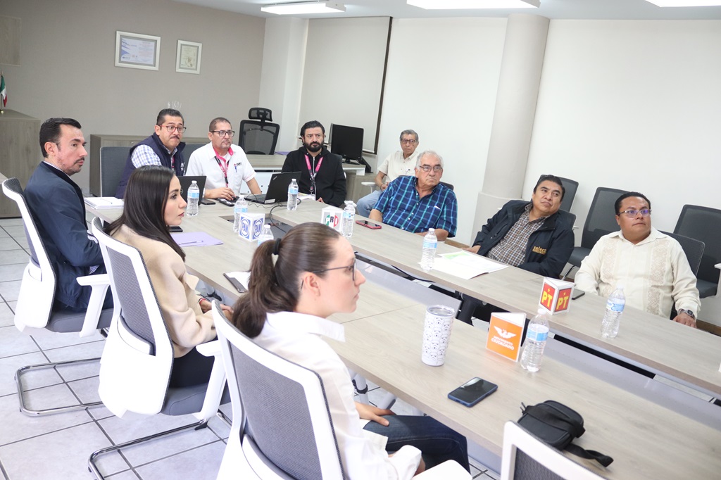 Nueve personas sentadas en una mesa alargada