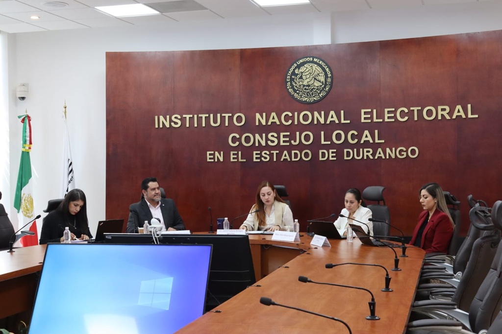 cinco personas sentadas frente a una mesa con micrófonos