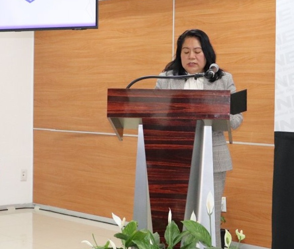 mujer de pie frente a un atril con micrófono