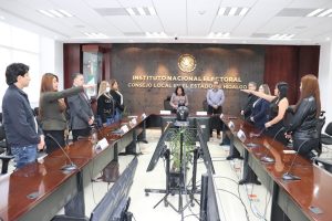 Once personas de pie reunidas detrás de una mesa