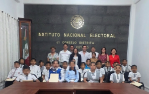 personas adultas de pie atrás de personas menores de edad sentadas