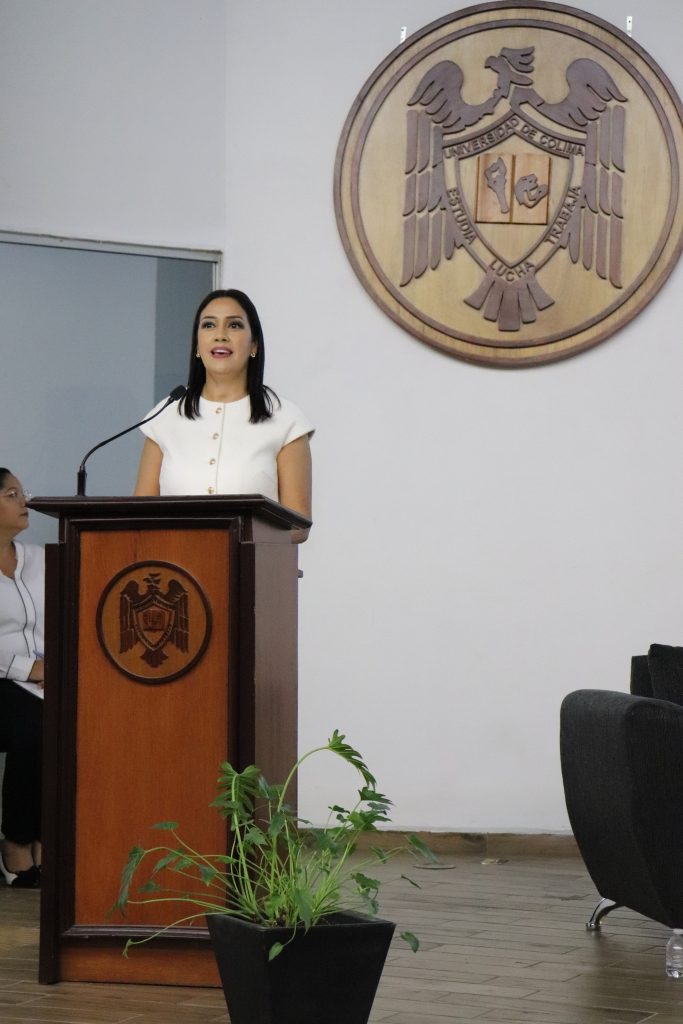 Mujer de pie hablando por micrófono de un atril