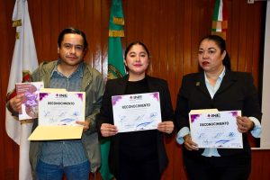 dos mujeres y un hombre sosteniendo reconocimientos