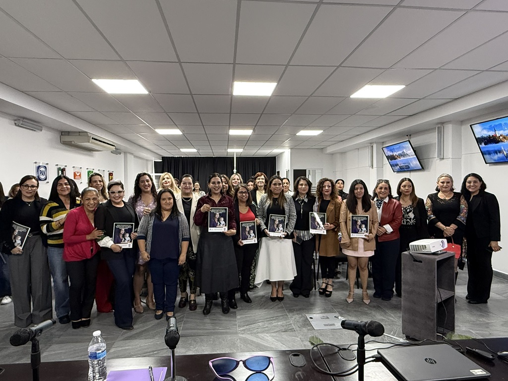 Más de veinte personas de pie, reunidas para la toma de una fotografía.