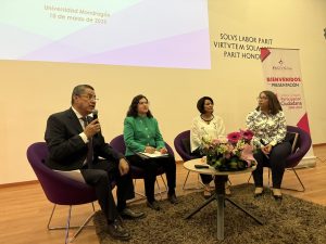 Cuatro personas sentadas reunidas detrás de una mesa redonda