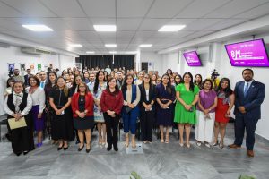 Más de 40 personas reunidas de pie sonrientes para una foto