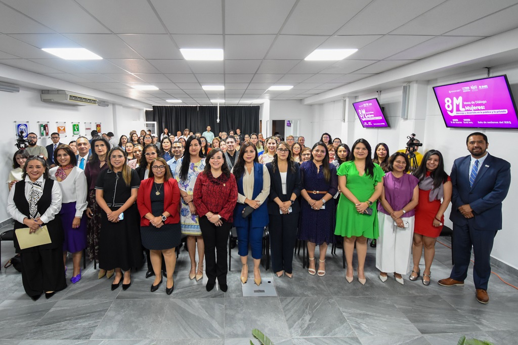 Más de 40 personas reunidas de pie sonrientes para una foto