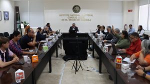 varias personas votando a mano alzada