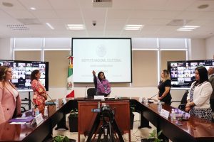 Cinco mujeres de pie reunidas detrás de una mesa