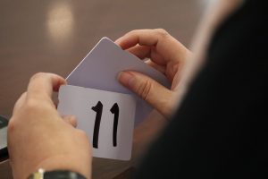 manos de una persona sosteniendo una tarjeta con el número 11
