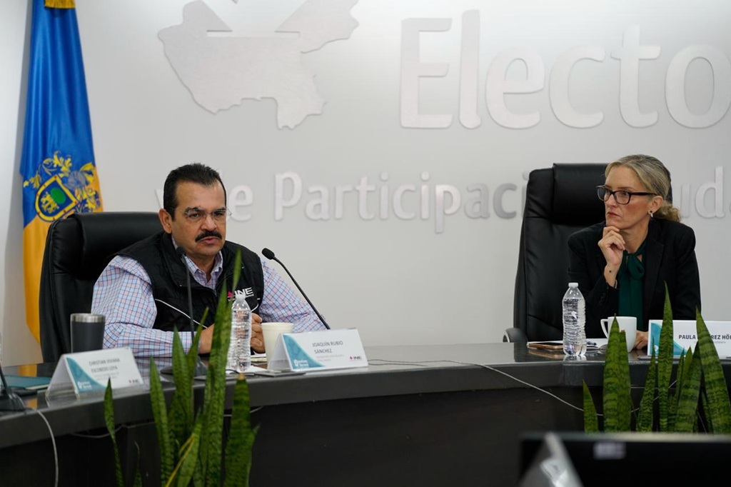 una mujer y un hombre sentados frente a micrófonos