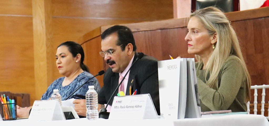 un hombre de lentes y bigote hablando frente a un micrófono delgado