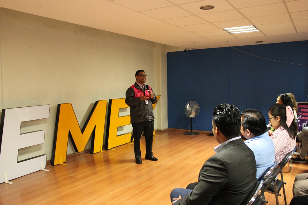 un hombre de pie hablando frente a personas sentadas