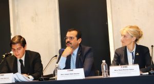 Tres personas sentadas frente a micrófonos