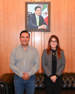 una mujer y un hombre de pie bajo una fotografía