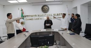 cuatro personas de pie alrededor de una mesa rectangular