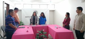 cinco personas de pie, en medio dos mujeres