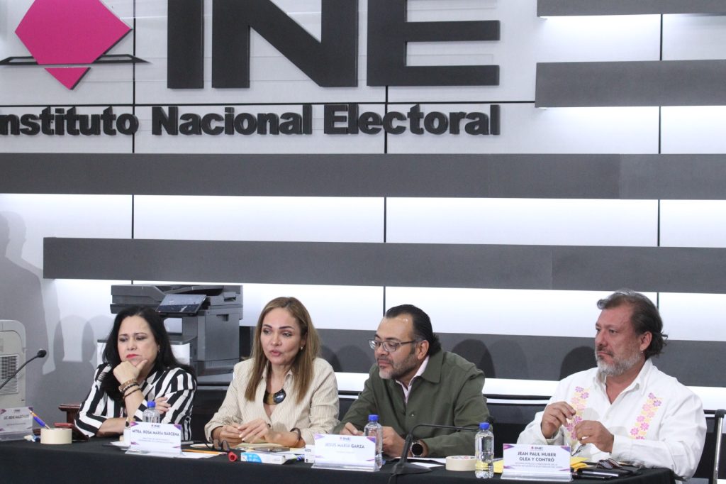 Personas participantes sentadas en el estrado del auditorio participando en el evento.