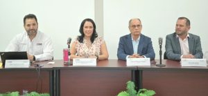 Una mujer y tres hombres sentados frente a una mesa