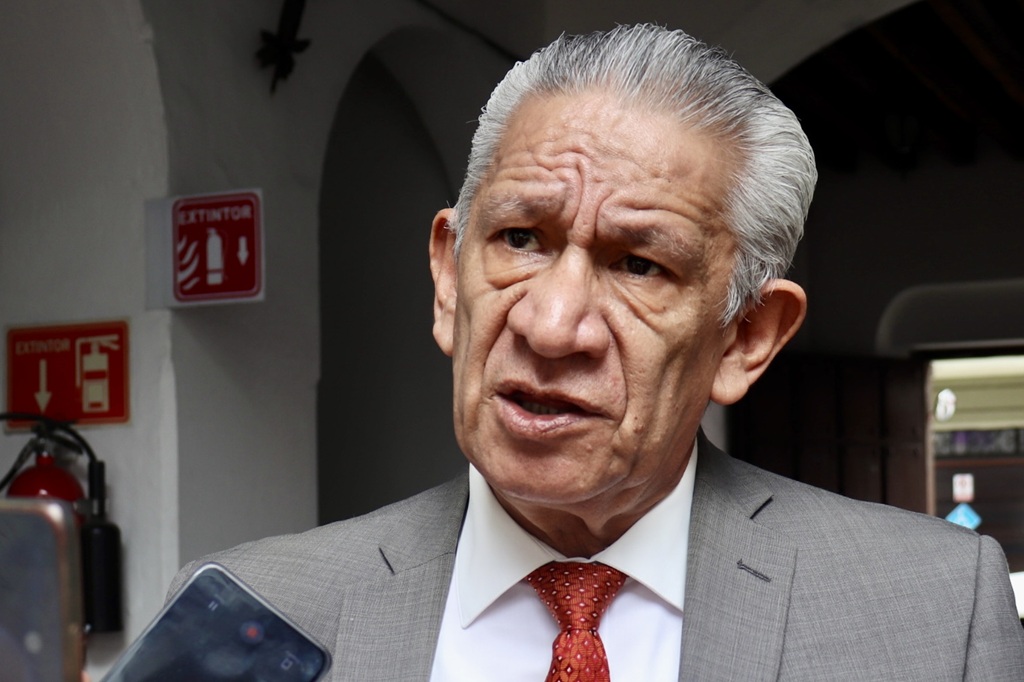 hombre de cabello cano hablando frente a un celular