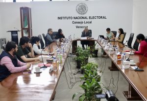 varias personas sentadas alrededor de una mesa ovalada de madera